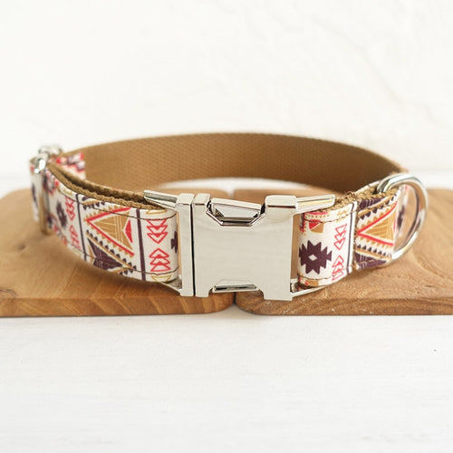 Dog collar with patterned strap and metallic buckle on a wooden surface