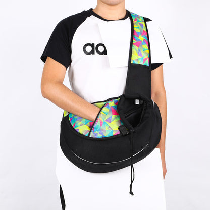 Person wearing a black and white shirt with a colorful green geometric-patterned bag over their shoulder on a white background